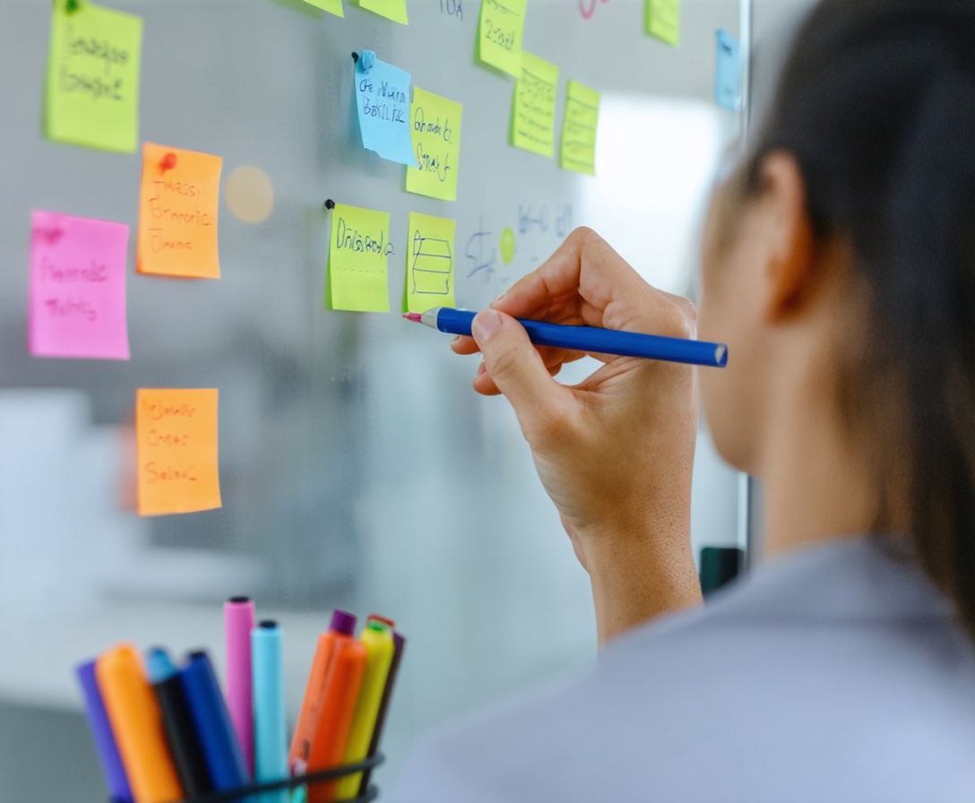 Tím pri strategickom plánovaní a brainstormingu na sklenenej tabuli